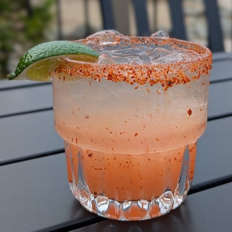 A Cold Springs Crossing Bar & Grill margarita with a chili-lime rim and lime wedge.